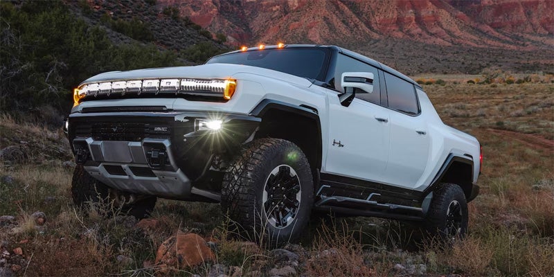 White GMC Hummer EV running offroading in mountain area