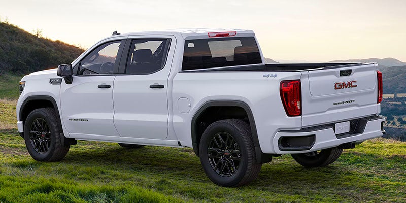 white GMC sierra running in hill area