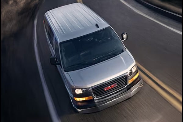 Gray GMC savana running on road