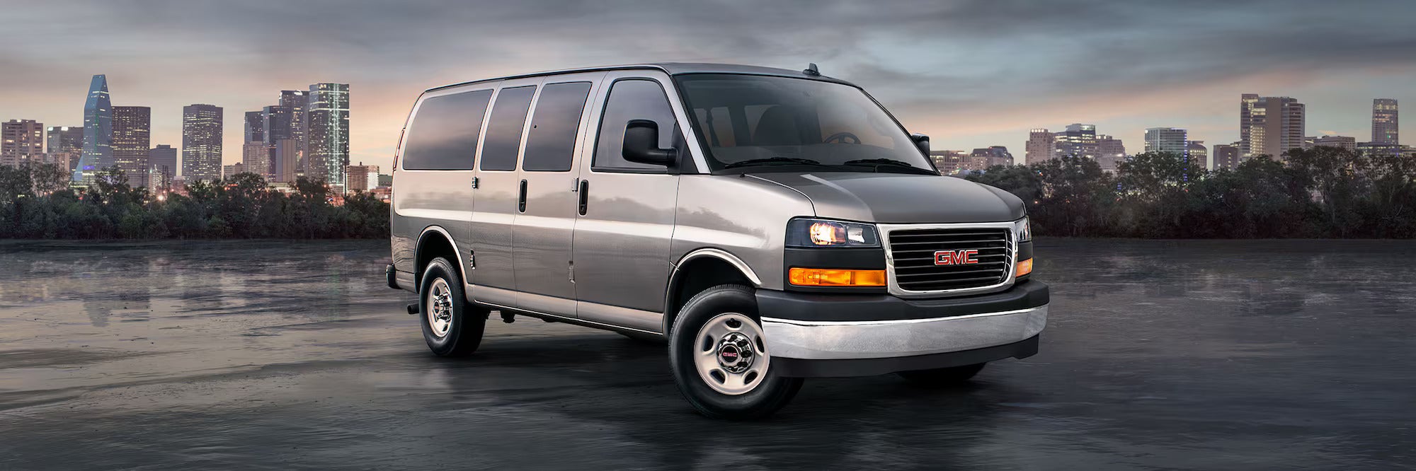 Gray GMC savana passenger van standing in parking area